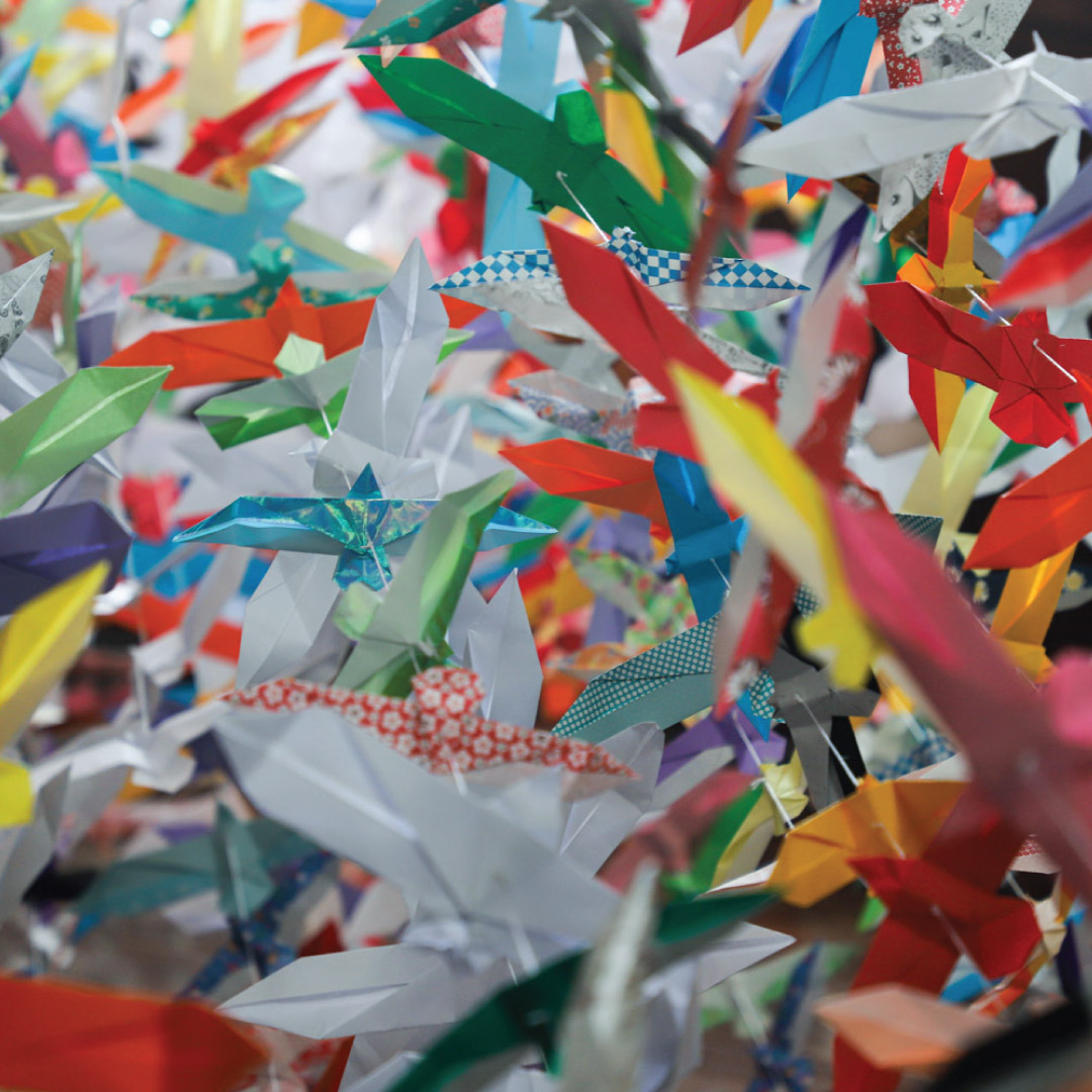 massive flock of origami seagulls in different paper